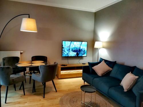 ein Wohnzimmer mit einem Sofa und einem Tisch in der Unterkunft Długie Ogrody Apartment 209 Gdańsk in Danzig