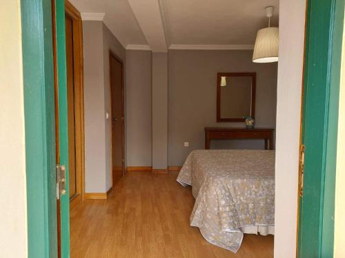 um quarto vazio com uma cama e um espelho em Casa Cabanas do Douro em Torre de Moncorvo