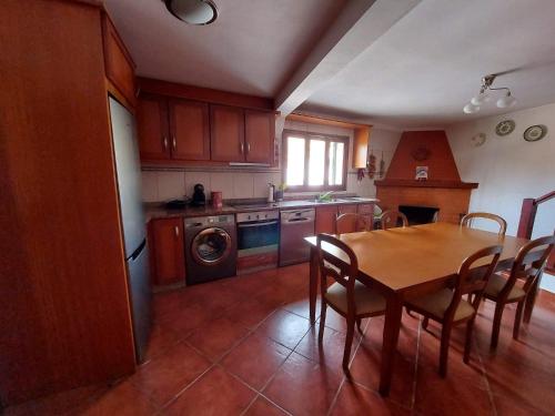 a kitchen with a table and chairs and a kitchen with a dishwasher at Casa Cabanas do Douro in Torre de Moncorvo