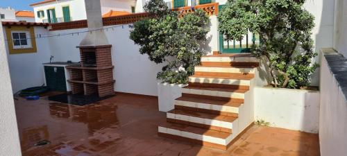a staircase in a courtyard with a house at Casa do Mar em Porto Covo in Porto Covo