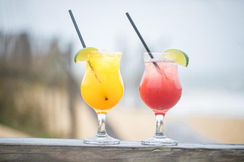 two cocktails sitting on top of a wooden rail at The Sea Ranch Resort in Kill Devil Hills