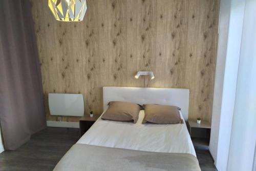 a bedroom with a white bed with two pillows at Studio Guest House à 5 minutes de Caen in Fontaine-Étoupefour