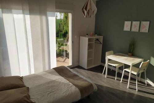 a bedroom with a bed and a table with chairs at Studio Guest House à 5 minutes de Caen in Fontaine-Étoupefour