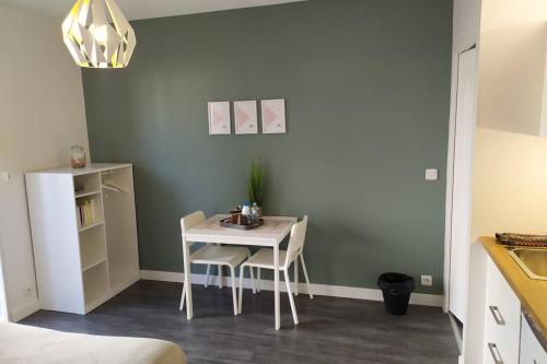 una mesa pequeña y sillas en una habitación en Studio Guest House à 5 minutes de Caen en Fontaine-Étoupefour
