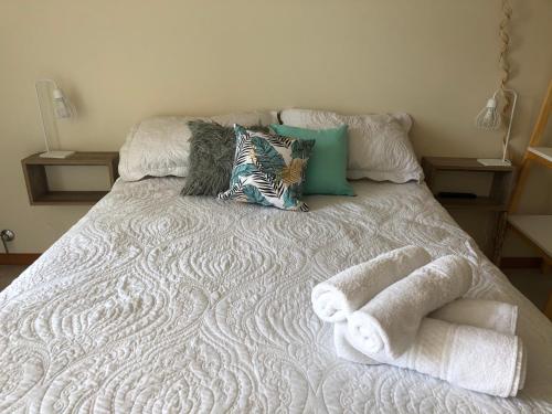 a bed with towels and pillows on it at Arenas- Departamento de playa in Puerto Madryn