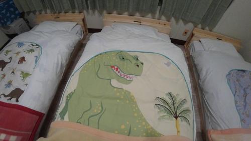 two twin beds with a dinosaur painted on them at BBQ可 1日1組限定 貸切別荘 秘密基地 は恐竜博物館まで3km スキージャム勝山まで12km in Katsuyama