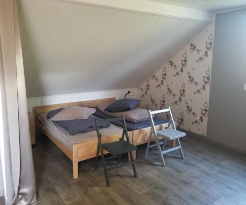 ein kleines Schlafzimmer mit einem Bett und einem Stuhl in der Unterkunft La Maison des Joel's in Schorbach