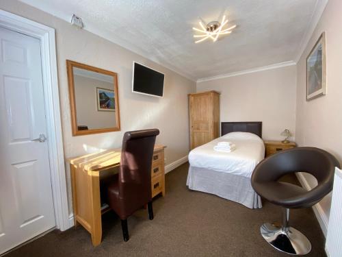 a bedroom with a desk and a bed and a desk at Fairlawns Guest House in Banbury