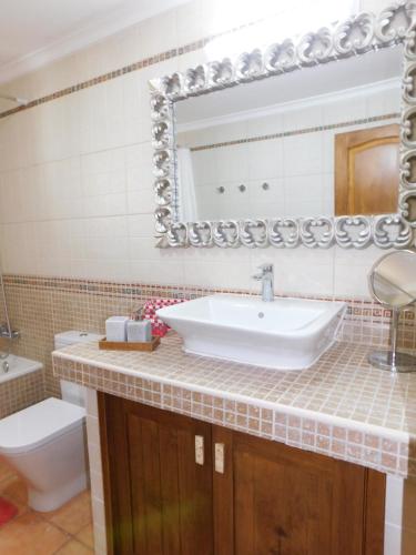 a bathroom with a sink and a toilet and a mirror at Casa La Florida in Tuineje