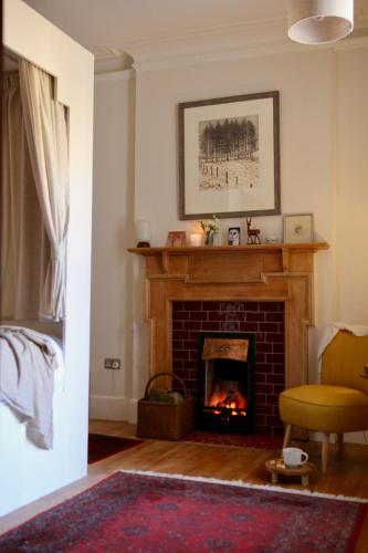 a living room with a fireplace and a chair at Home Farm Oban in Oban