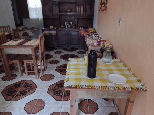 a kitchen with a table with a yellow table cloth on it at Pousada Bruluka in Tiradentes