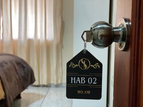 a tag hanging from a door knob with aha on it at Hotel Casa Santa Lucía in Baños