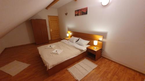 a bedroom with a large bed and two lamps at Vila Panselutelor 6 in Sinaia