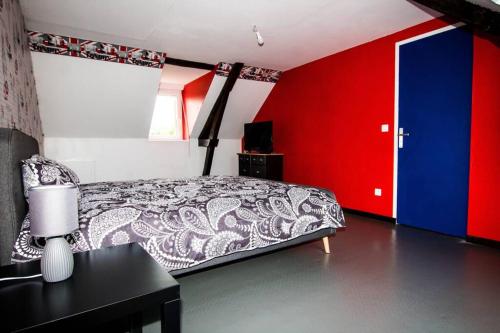 克萊西的住宿－La Maison réseau Cycle et Gites，一间卧室设有一张床和蓝色和红色的墙壁