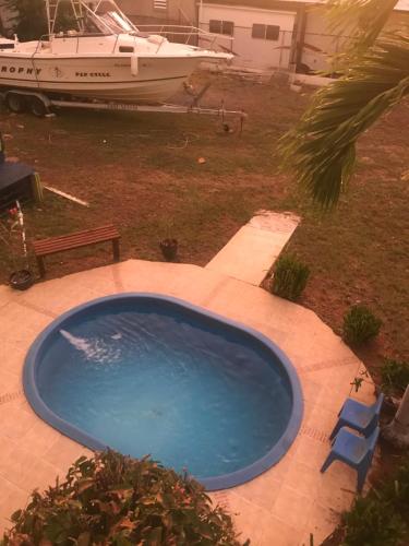 a large blue pool with a bench and a boat at Combate Green House in Cabo Rojo