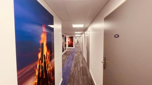 a hallway with a painting on the wall at Hotelli Loimu by UHANDA in Raisio
