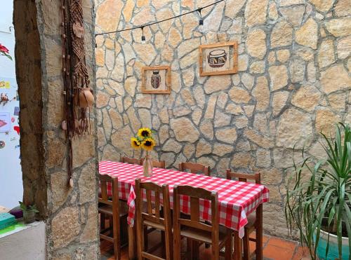 una mesa con un jarrón de girasoles en la parte superior en Hostal La Isla en San Cristóbal de Las Casas
