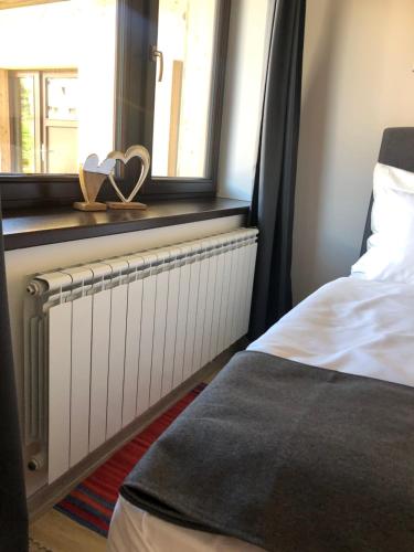 a bedroom with a radiator and a window with a pair of hearts at Studia Imrvere in Žamberk