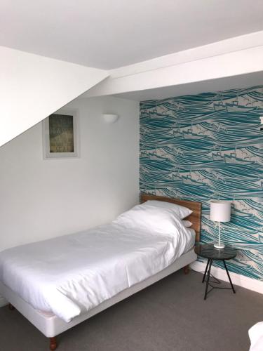 a bedroom with a bed and a wall with a mural at High Tide in Whitby