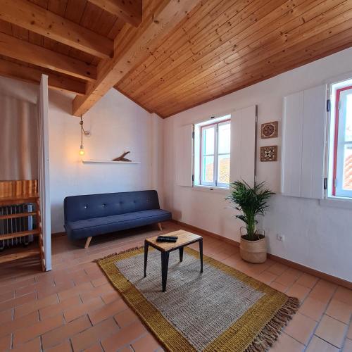 a living room with a blue couch and a table at Alba Odeceixe - casa alta in Odeceixe