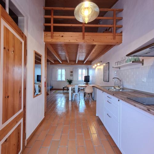 a kitchen with a counter and a table in a room at Alba Odeceixe - casa alta in Odeceixe