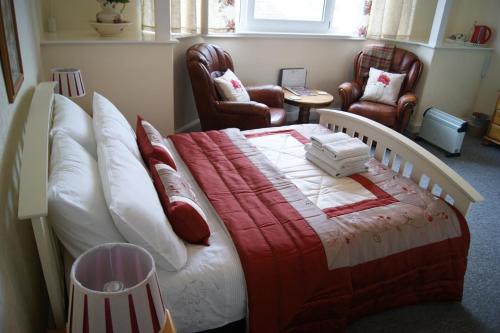 a bedroom with a bed with a red and white blanket at Sunset Guest House in Hunstanton