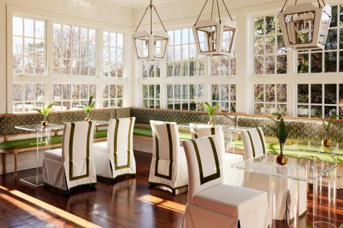 a dining room with a table and chairs and windows at Kennebunkport Captains Collection in Kennebunkport