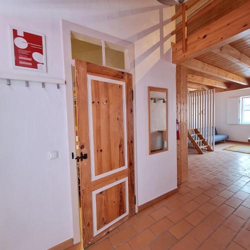 a room with a door and a hallway with stairs at Alba Odeceixe - casa alta in Odeceixe
