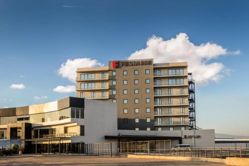 a tall building with a red sign on top of it at Fiesta Inn Guadalajara Aeropuerto in Guadalajara