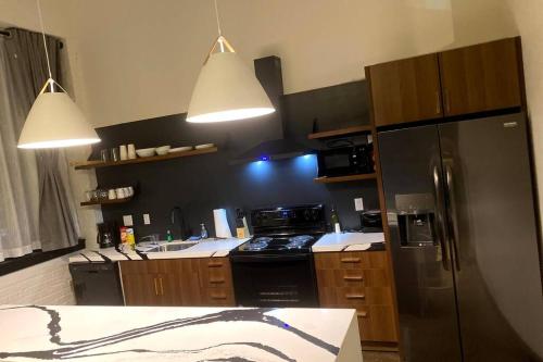 a kitchen with a stainless steel refrigerator and two lights at 3E-*New* 3 min to Hillman Cancer Center, Sleeps 6 in Pittsburgh