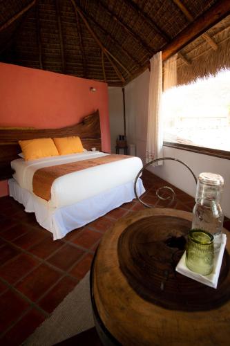 a bedroom with a bed and a table with a table at Quinta Ascensión Hotel Boutique Only Adults in Malinalco