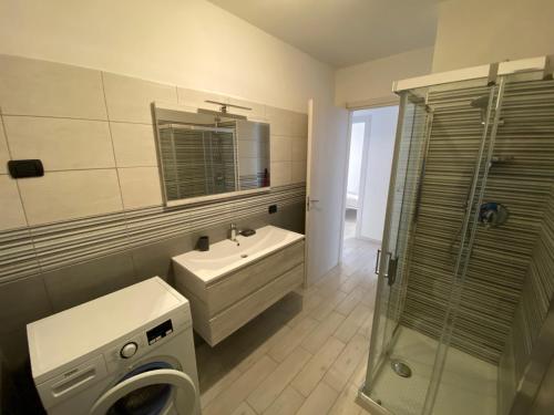 ein Badezimmer mit einem Waschbecken und einer Waschmaschine in der Unterkunft Residenza al Parco Termale - Comano Terme in Comano Terme