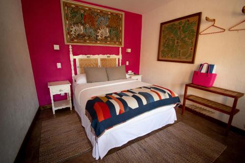 a bedroom with a bed and a pink wall at Quinta Ascensión Hotel Boutique Only Adults in Malinalco
