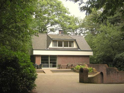 a brick house with a window on top of it at Holiday home with pool sauna in Lunteren
