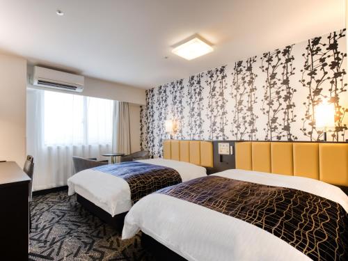 2 camas en una habitación de hotel con papel pintado en APA Hotel Takamatsu Airport, en Takamatsu