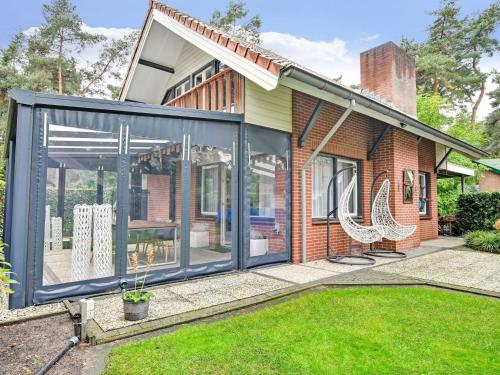 uma extensão a uma casa com portas de vidro em Charming holiday home with a covered terrace em Meijel