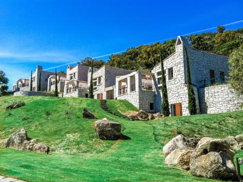 a large house on top of a hill with rocks at BGItalianVacation - Ville Li Conchi in Castiadas