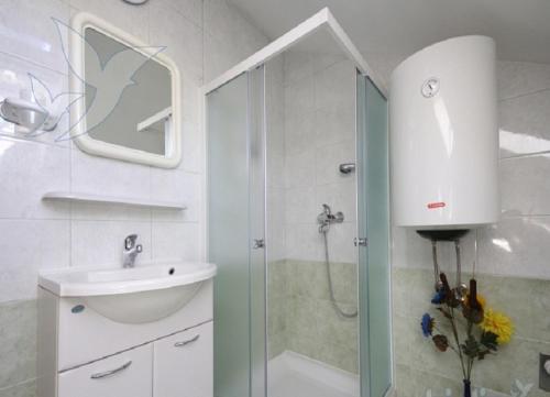 ein Bad mit einer Dusche und einem Waschbecken in der Unterkunft Apartments Stosa - with parking in Nin