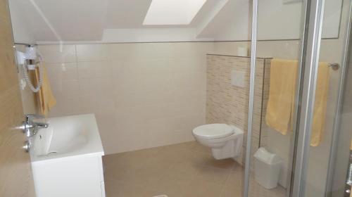 a bathroom with a toilet and a sink and a shower at Garni Pircher in Tirolo