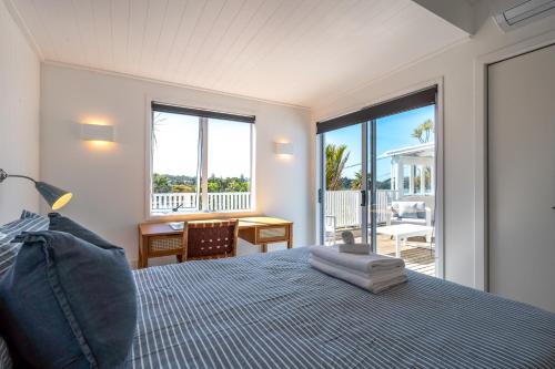 a bedroom with a bed and a view of the ocean at Bluebelle - Stay Waiheke in Oneroa