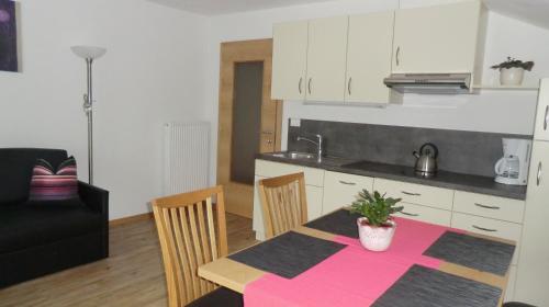 a kitchen and dining room with a table and chairs at Garni Pircher in Tirolo