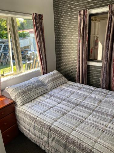 a bedroom with a bed in front of a window at Windsor Motel in Taupo