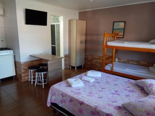 een kamer met een bed en een keuken met een aanrecht bij Pousada do Recanto Feliz in Torres