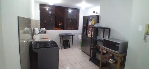 a small kitchen with a refrigerator and a microwave at Arena Costa Lima rooms Peru in Lima