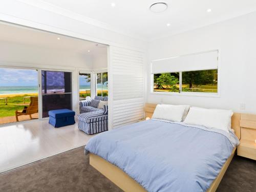 um quarto com uma cama e vista para o oceano em Comfy Beachfront Unit, Unbeatable Location & Views em Avoca Beach