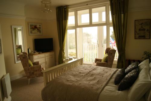 a bedroom with a bed and a large window at Sunset Guest House in Hunstanton