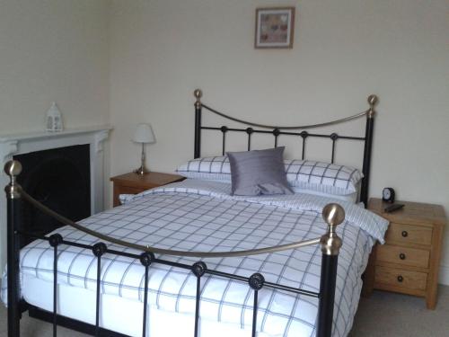 a bedroom with a large bed with a black frame at The Bradworthy Inn in Holsworthy