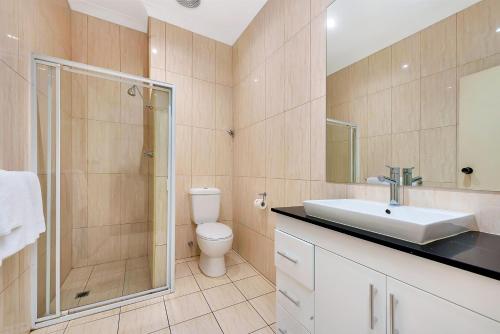 
a bathroom with a toilet, sink, and shower at Comfort Inn & Suites Sombrero in Adelaide
