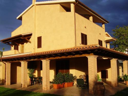 a large house with a porch and a patio at Appartamenti Gli Ulivi Di Maremma in Gavorrano