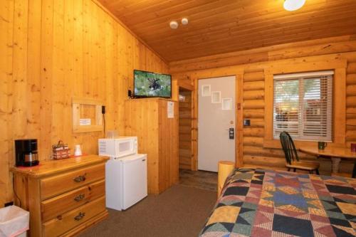 1 dormitorio con 1 cama y escritorio con microondas en Teton Valley Cabins, en Driggs